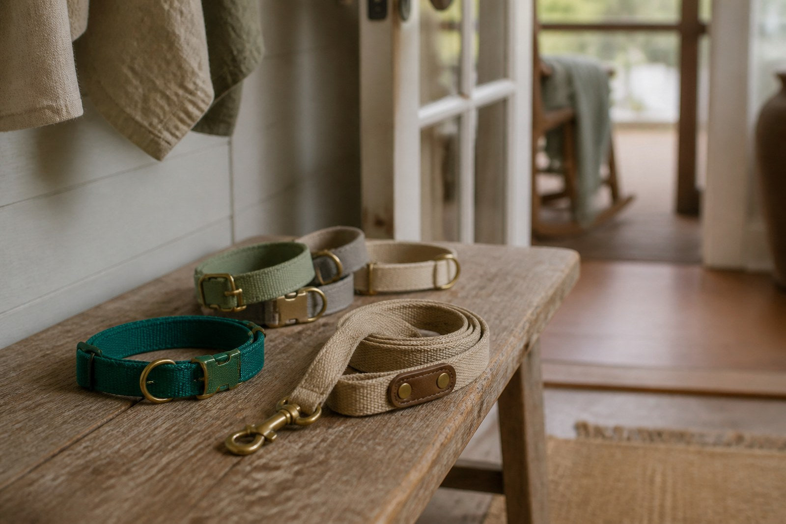Dog collars and a leash laid out on a wooden entryway bench.